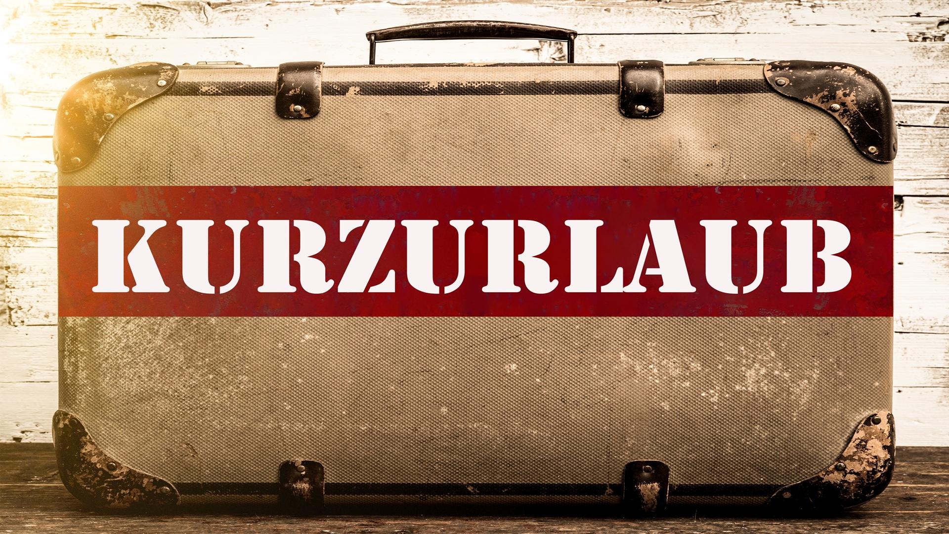 Alter Koffer mit Schriftzug Kurzurlaub auf Holztisch | Wellnesshotel